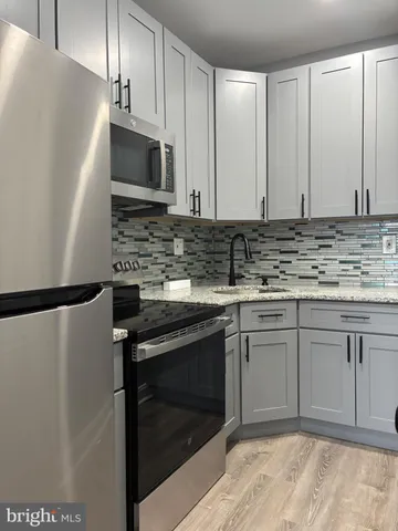 a kitchen with stainless steel appliances granite countertop a stove a refrigerator and a sink