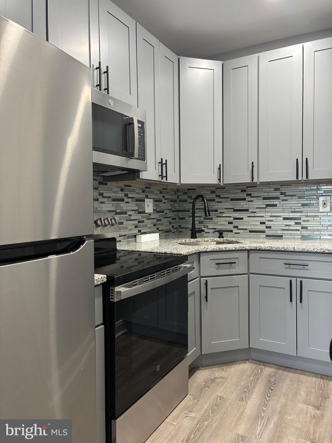 5812 Willows Avenue Philadelphia, PA 19143 - Photo 17 of 27 a kitchen with stainless steel appliances granite countertop a stove a refrigerator and a sink