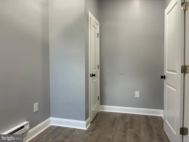 an empty room with wooden floor and entrance
