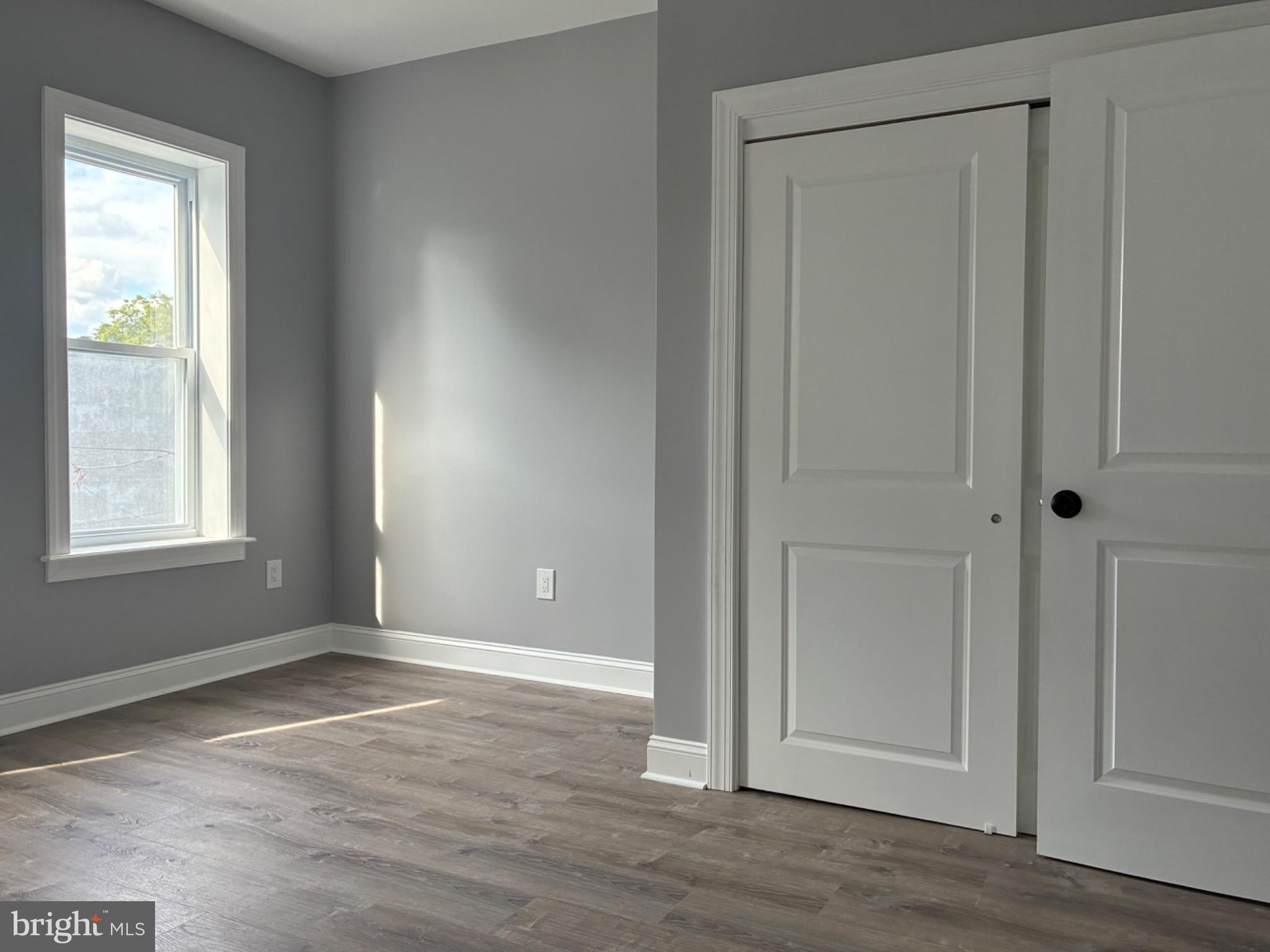 5812 Willows Avenue Philadelphia, PA 19143 - Photo 21 of 27 an empty room with wooden floor and windows