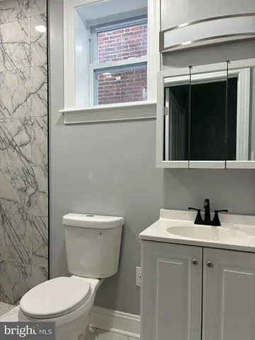 a bathroom with a toilet a sink and a window