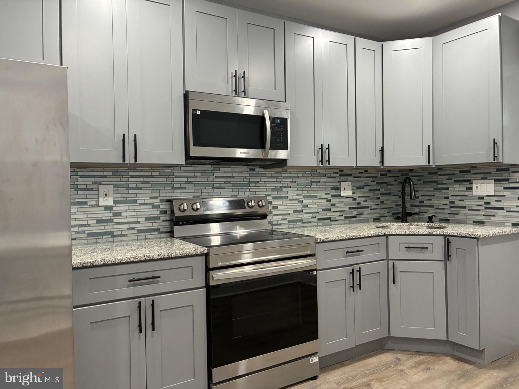 5812 Willows Avenue Philadelphia, PA 19143 - Photo 6 of 27 a kitchen with stainless steel appliances granite countertop a sink stove and microwave