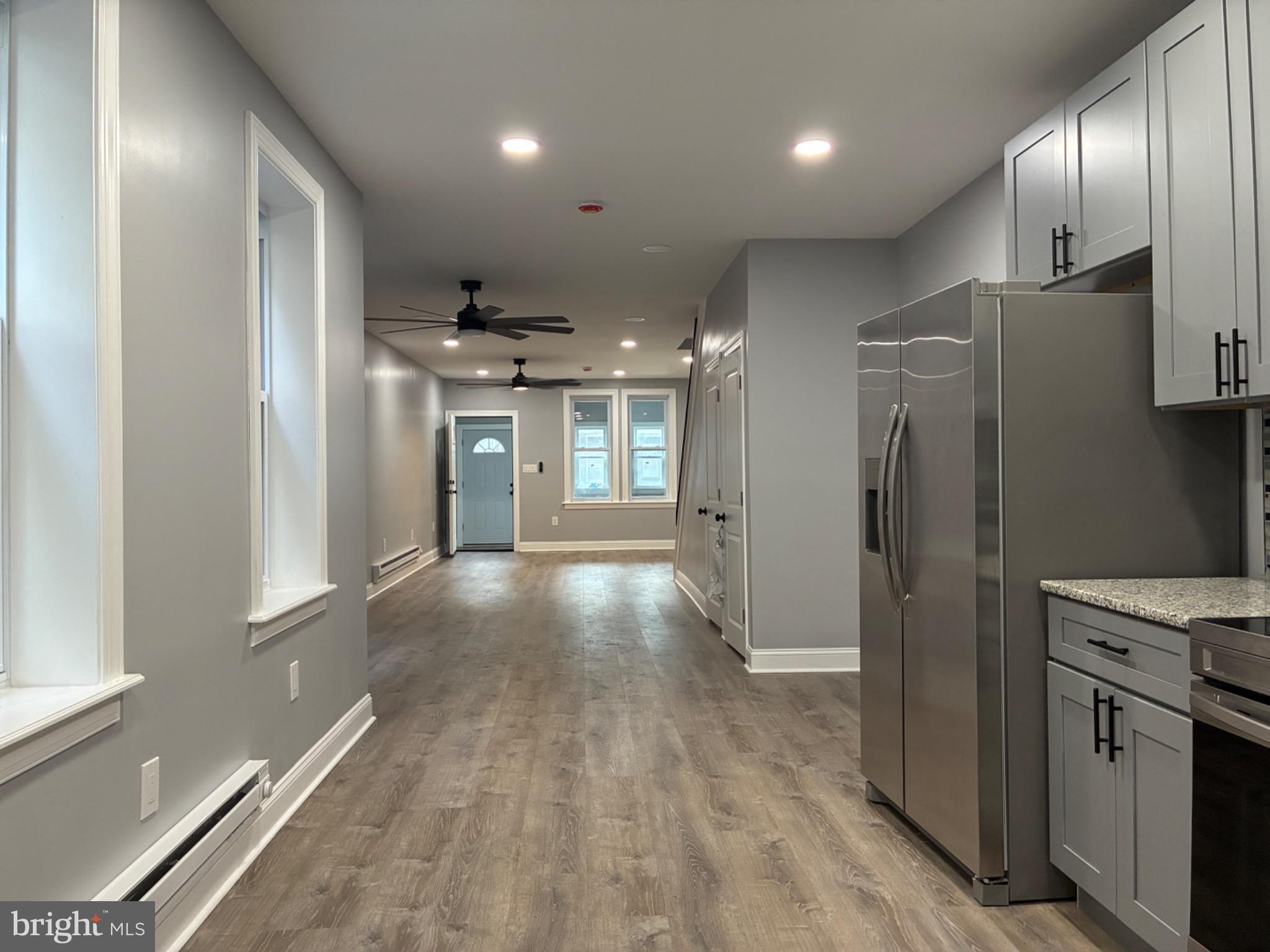 5812 Willows Avenue Philadelphia, PA 19143 - Photo 7 of 27 a view of a refrigerator in kitchen and wooden floor