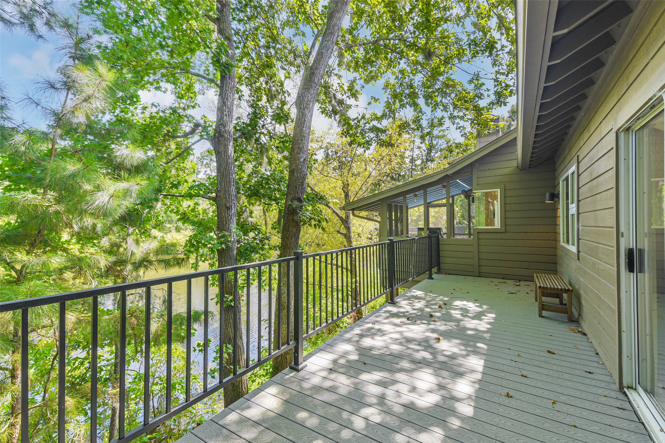 88 Raccoon Ramble Cleveland, TX 77327 - Photo 37 of 43 Expansive deck overlooking lush greenery and a serene water view, perfect for relaxing or entertaining outdoors.