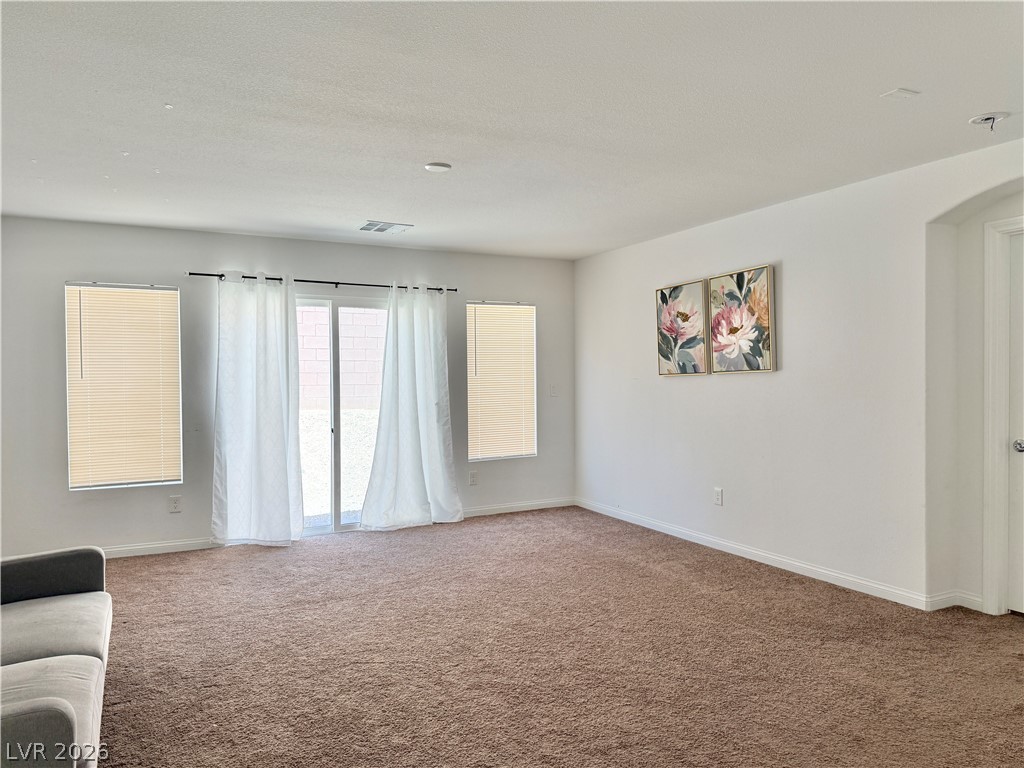 7777 South Westwind Road Las Vegas, NV 89139 - Photo 10 of 46 A spacious living room offering comfort and ample natural light through sliding glass doors.