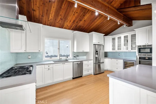 a kitchen with granite countertop a sink stainless steel appliances and cabinets