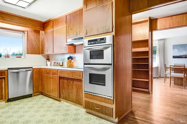 a kitchen with stainless steel appliances granite countertop a refrigerator a stove and a sink with cabinets