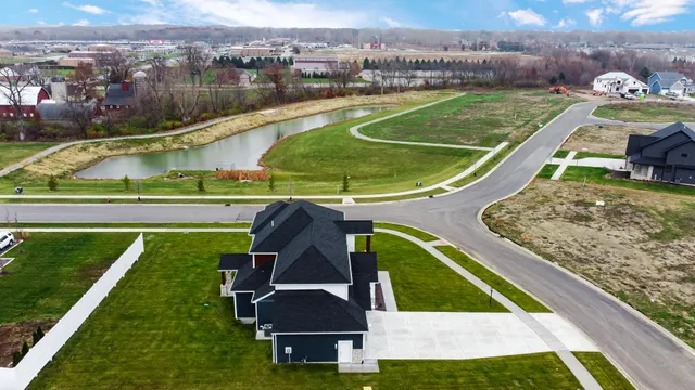 an aerial view of a house with a garden and lake view