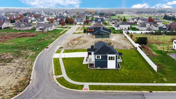 a kitchen with stainless steel appliances kitchen island granite countertop a refrigerator a sink and white cabinets