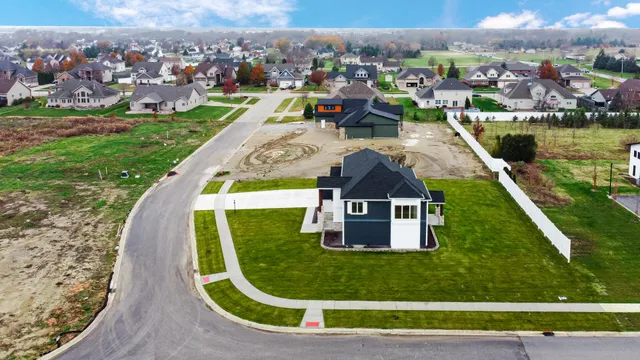 a kitchen with stainless steel appliances kitchen island granite countertop a refrigerator a sink and white cabinets