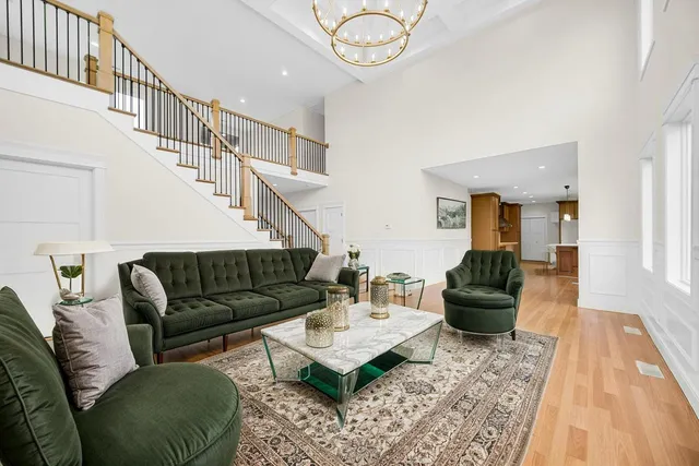 a living room with furniture a rug and a chandelier