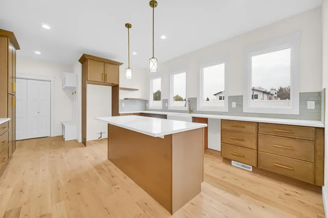 a kitchen with kitchen island a stove a counter space and a sink