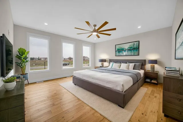 a spacious bedroom with a bed and a chandelier