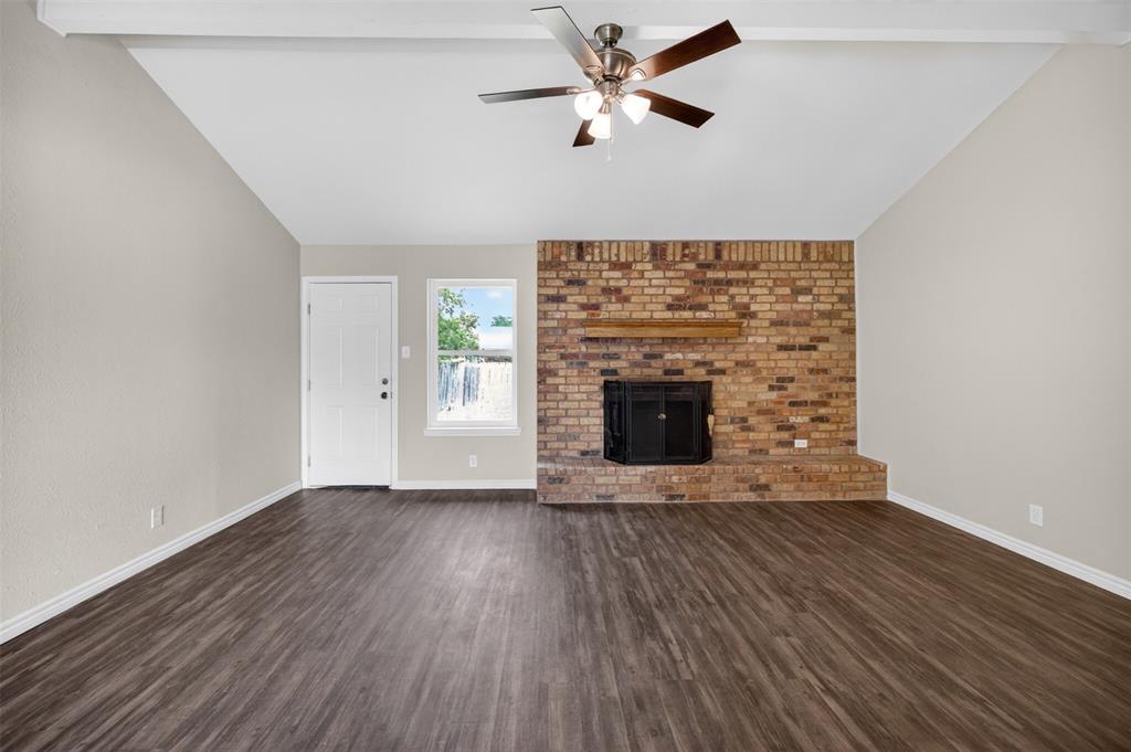 7528 Meadowlark Lane North Watauga, TX 76148 - Photo 8 of 31 a view of an empty room with wooden floor and a fireplace