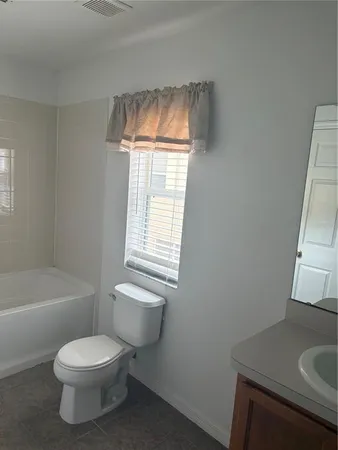 a white toilet sitting next to a bathroom sink
