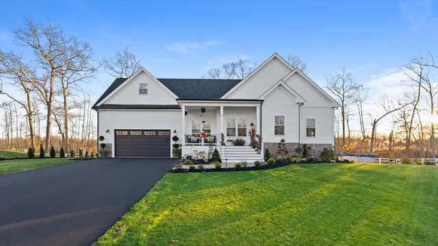 a front view of a house with a garden and trees