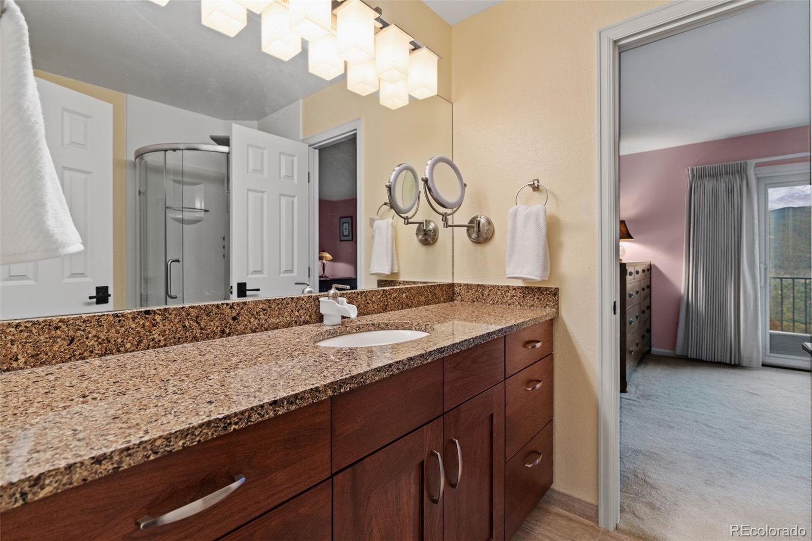830 Jesse Lane Bailey, CO 80421 - Photo 31 of 45 a bathroom with a granite countertop sink and a mirror