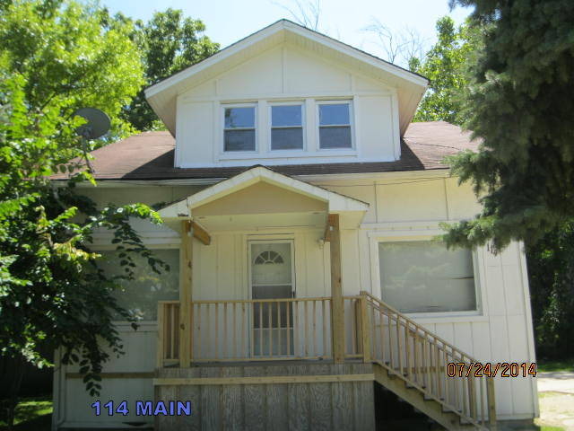 114 West Roosevelt Road Wheaton, IL 60187 - Photo 1 of 16 a view of a brick house with large windows and a small yard