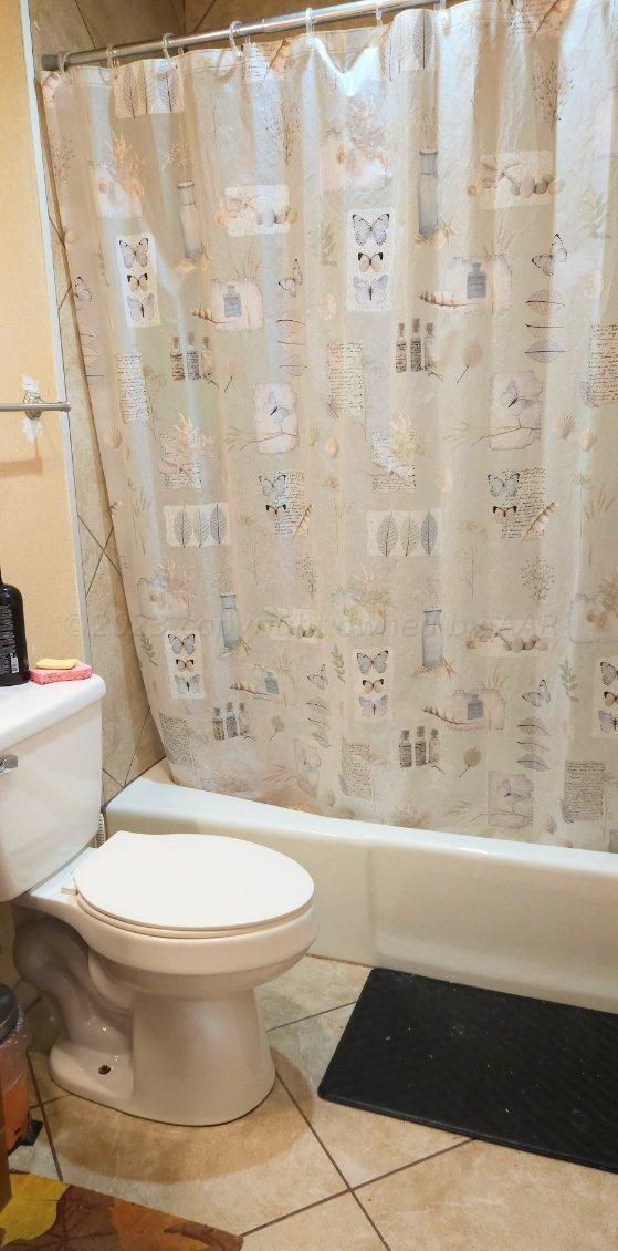 604 Pine Avenue Dumas, TX 79029 - Photo 8 of 13 a bathroom with a toilet and a bathtub