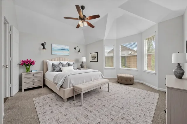 a bedroom with a large bed and a chandelier