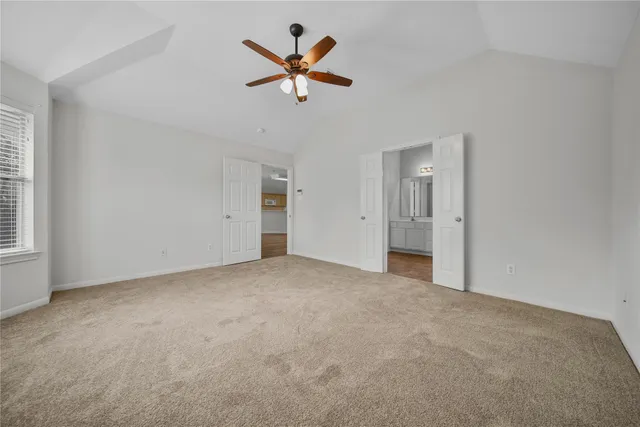 an empty room with ceiling fan and window