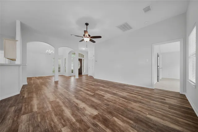 a view of a room with wooden floor and ceiling fan