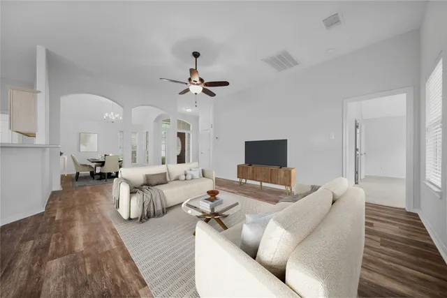 a living room with furniture and a wooden floor