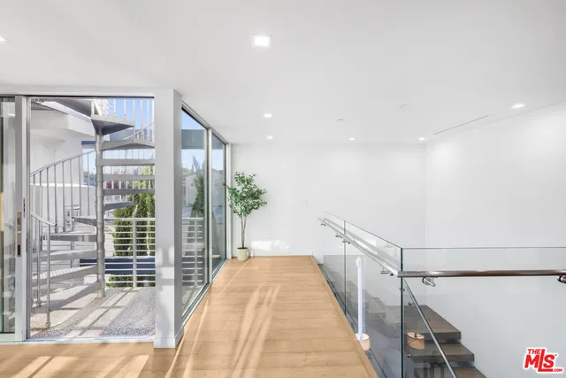 a view of a hallway with wooden floor and windows