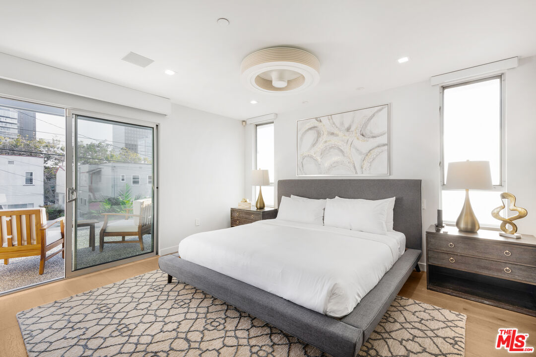 6410 Lindenhurst Avenue Los Angeles, CA 90048 - Photo 17 of 39 a bedroom with a bed and glass window