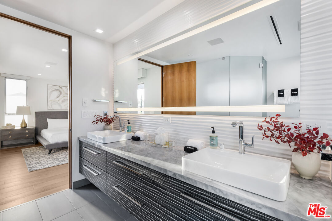 6410 Lindenhurst Avenue Los Angeles, CA 90048 - Photo 18 of 39 a bathroom with a sink mirror and vanity