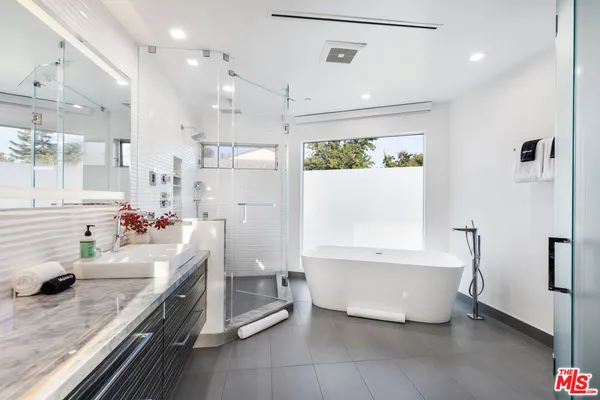 a bathroom with a tub sink and mirror