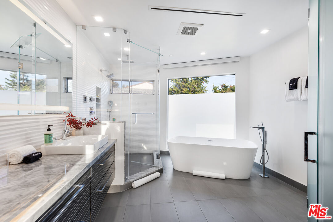6410 Lindenhurst Avenue Los Angeles, CA 90048 - Photo 19 of 39 a bathroom with a tub sink and mirror