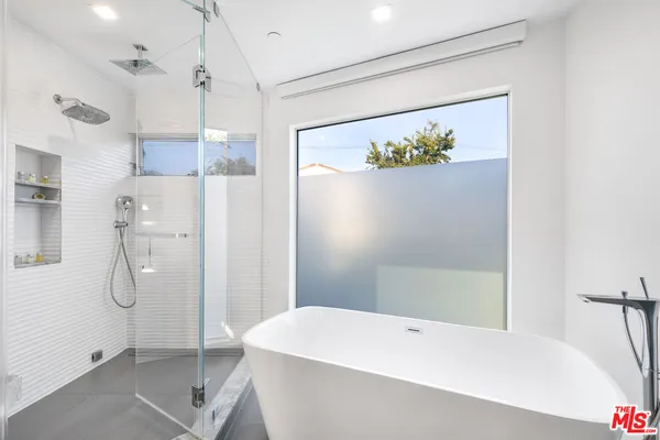 a bathroom with a bathtub a shower a toilet and a shower