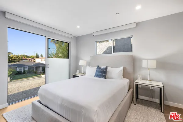 a bedroom with a bed and a large window