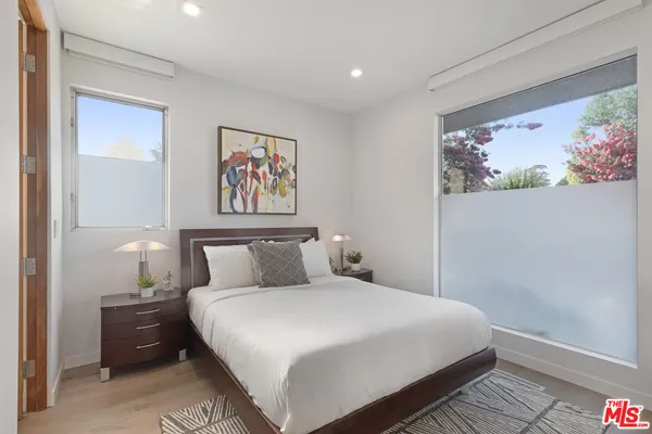 a bedroom with a bed and a painting on the wall