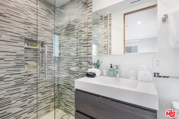 a bathroom with a sink a mirror and shower