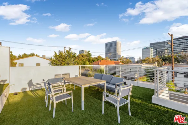 a view of a chairs and table in patio with a yard