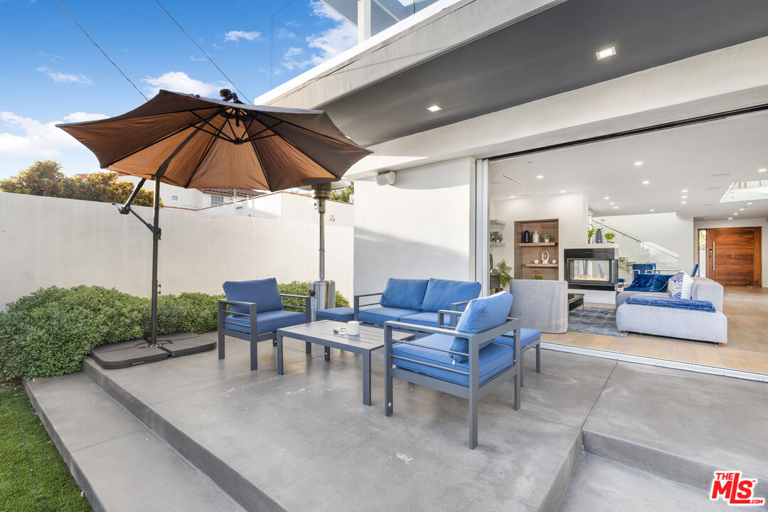6410 Lindenhurst Avenue Los Angeles, CA 90048 - Photo 31 of 39 a view of a patio with a table and chairs under an umbrella