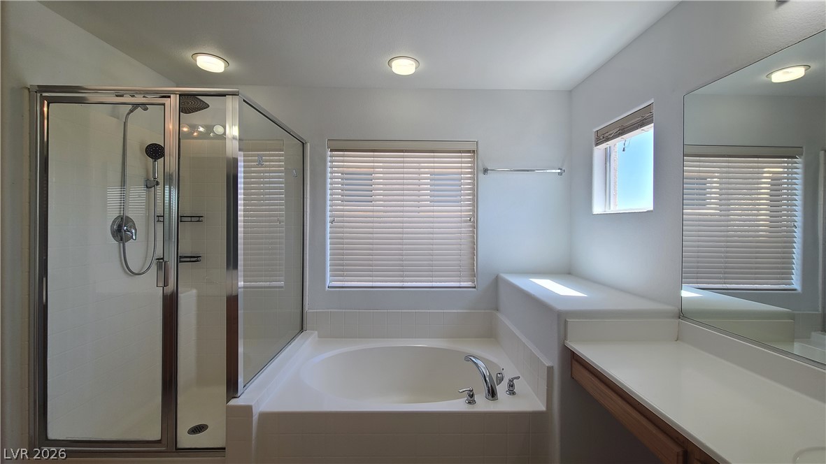 8944 Rutherford Grove Street Las Vegas, NV 89148 - Photo 17 of 35 Indulge in a tranquil primary bath featuring a generous soaking tub and an adjacent walk-in shower.