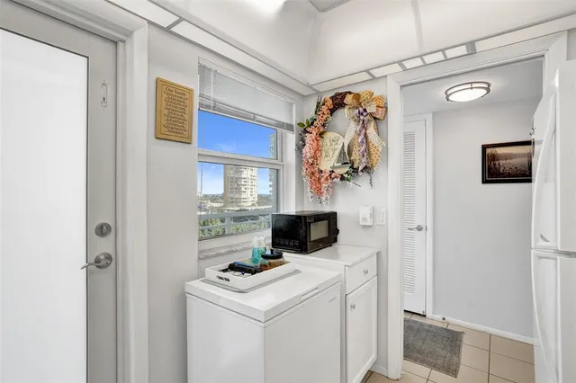a kitchen with stainless steel appliances a refrigerator a sink and white cabinets