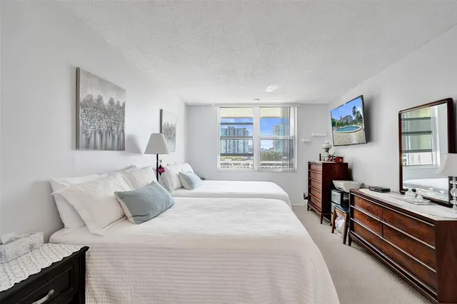 a bedroom with a bed and a lamp on dresser