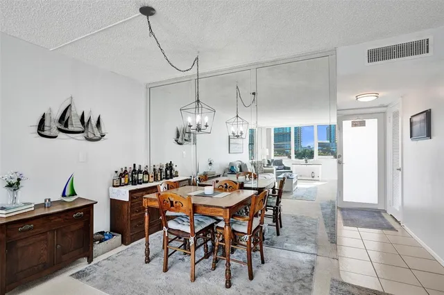 a living room with couches a fireplace and a dining table with wooden floor