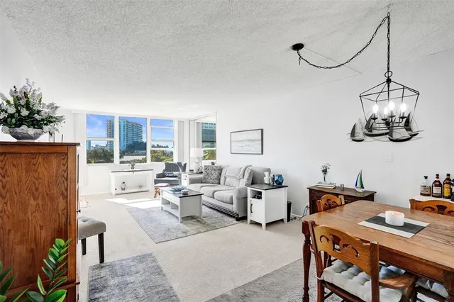a living room with furniture potted plant and a large window