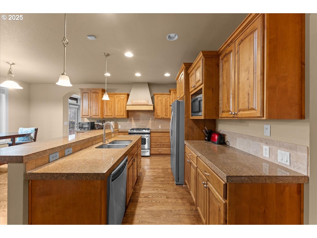 15485 Southwest Willamette Valley Court Beaverton, OR 97007 - Photo 11 of 48 a kitchen with stainless steel appliances granite countertop a sink stove and cabinets