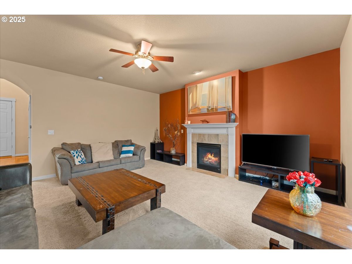 15485 Southwest Willamette Valley Court Beaverton, OR 97007 - Photo 18 of 48 a living room with furniture a fireplace and a flat screen tv