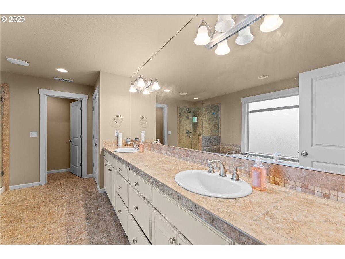 15485 Southwest Willamette Valley Court Beaverton, OR 97007 - Photo 25 of 48 a bathroom with a sink double vanity granite and a mirror