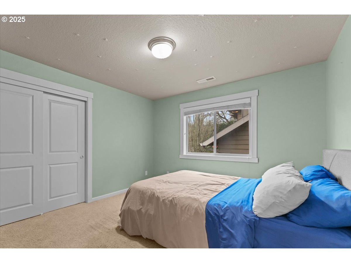15485 Southwest Willamette Valley Court Beaverton, OR 97007 - Photo 32 of 48 a bedroom with a bed and a painting on the wall