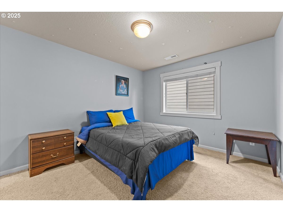 15485 Southwest Willamette Valley Court Beaverton, OR 97007 - Photo 36 of 48 a bedroom with a bed and a lamp