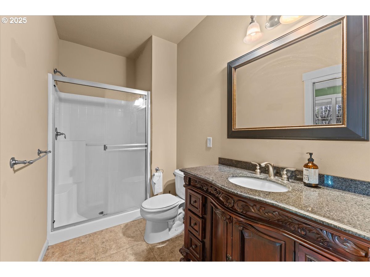 15485 Southwest Willamette Valley Court Beaverton, OR 97007 - Photo 42 of 48 a bathroom with a granite countertop sink toilet a mirror a vanity and shower