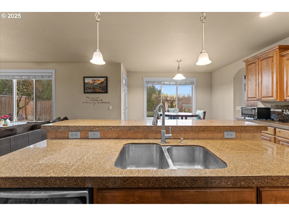 15485 Southwest Willamette Valley Court Beaverton, OR 97007 - Photo 10 of 48 a view of a kitchen with kitchen island a sink granite counter tops and a large window